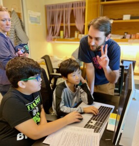 Ben sharing wisdom at the computer.